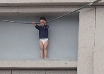 VÍDEO: Menino de 3 anos fica preso do lado de fora de prédio a 10 metros de altura na China